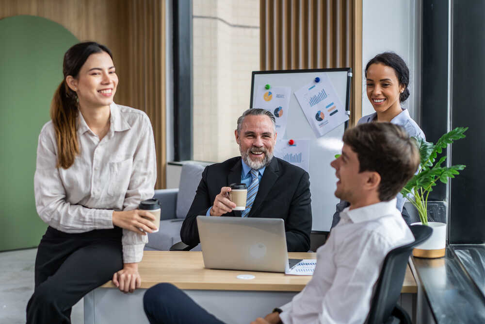 Group of young attractive business people working in office workplace. Attractive employee worker sitting on table desk and using laptop computer work and planing for company project of corperate.