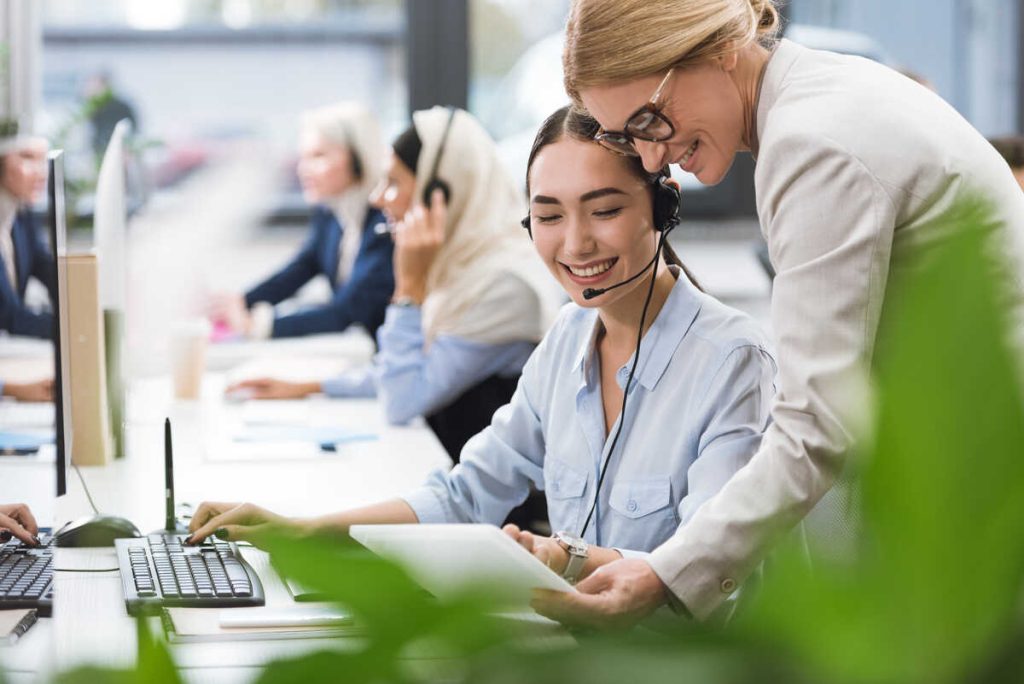 smiling multicultural businesswomen using tablet together at workplace in office.